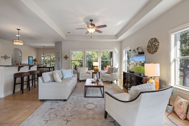 tiled living room with plenty of natural light, ceiling fan, and sink