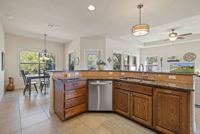 kitchen featuring stainless steel dishwasher, a healthy amount of sunlight, sink, and pendant lighting