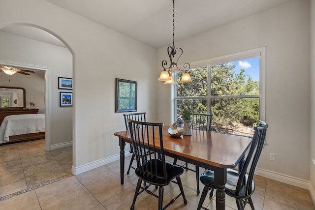 tiled dining room featuring ceiling fan with notable chandelier