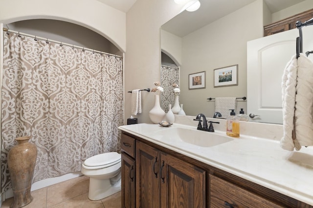 bathroom featuring toilet, vanity, a shower with shower curtain, and tile patterned floors