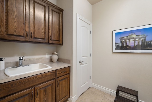 kitchen featuring sink, dark brown cabinets, and light tile patterned flooring