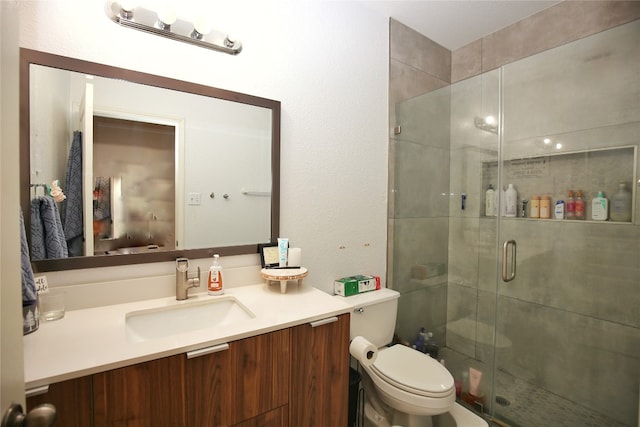 bathroom featuring an enclosed shower, toilet, and vanity