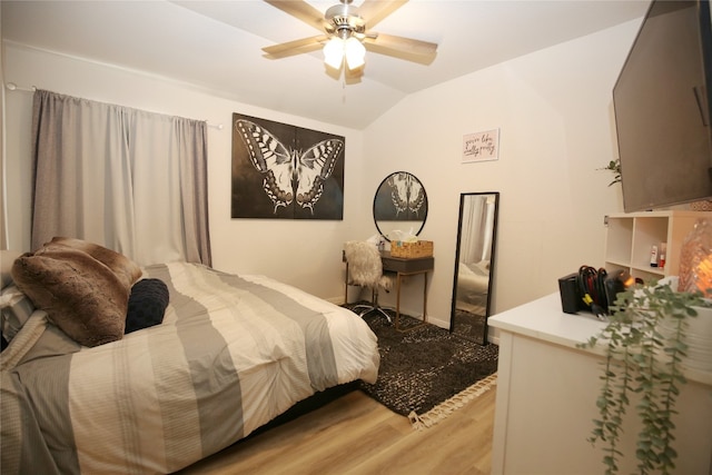 bedroom with ceiling fan, light hardwood / wood-style floors, and vaulted ceiling