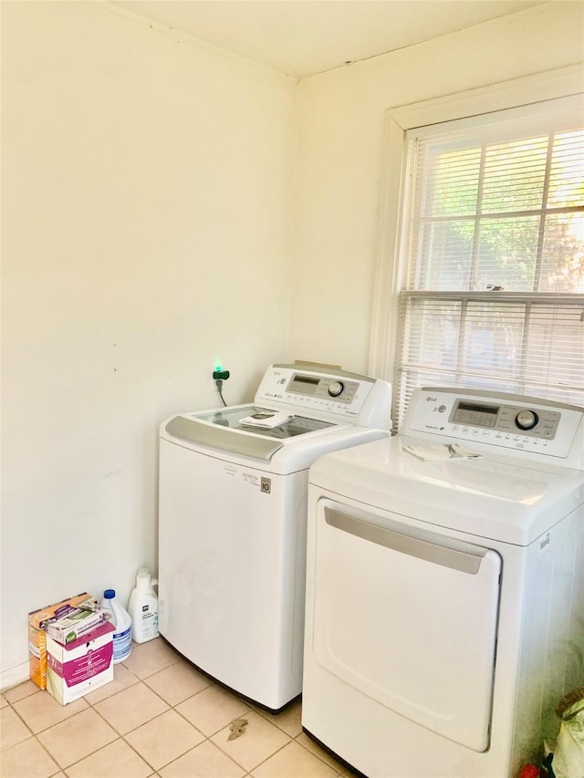 laundry room featuring light tile patterned floors and washing machine and clothes dryer