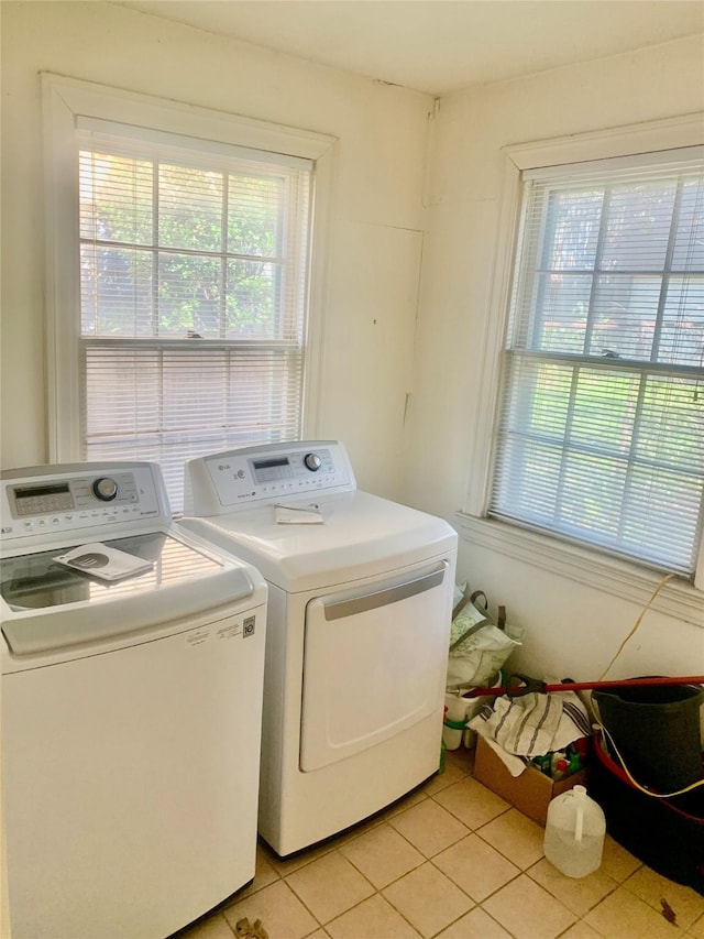 clothes washing area featuring separate washer and dryer and light tile patterned floors