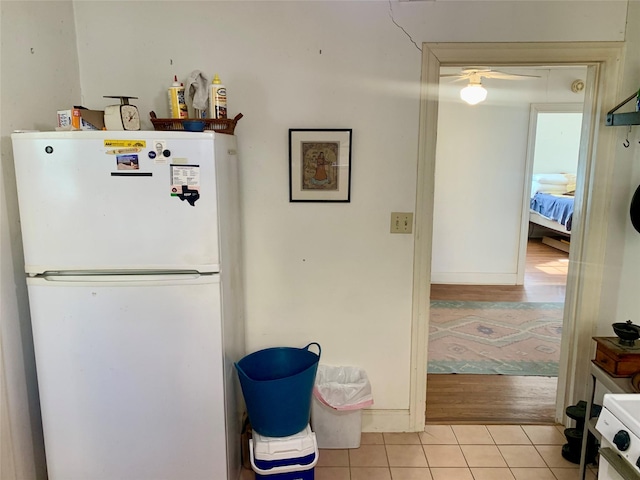 kitchen with white refrigerator, ceiling fan, and light tile patterned floors