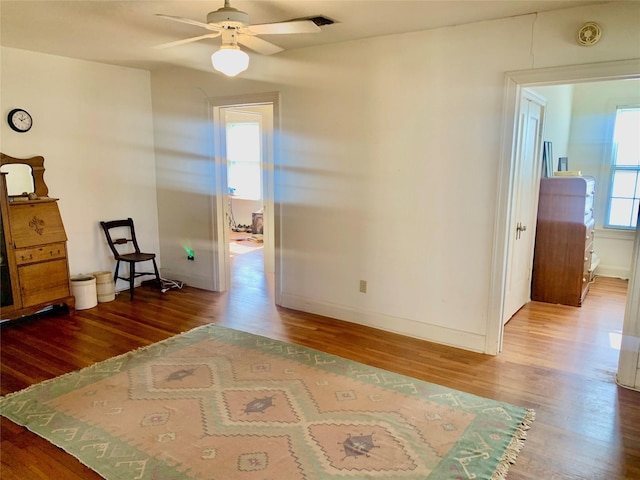 empty room with hardwood / wood-style flooring, a wealth of natural light, and ceiling fan