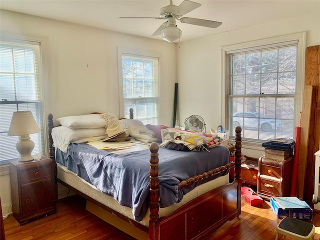 bedroom featuring multiple windows, hardwood / wood-style flooring, and ceiling fan