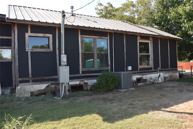 back of property featuring central AC and a lawn