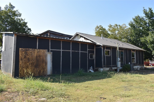 rear view of property featuring a sunroom and a lawn