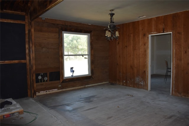 unfurnished dining area with a chandelier and wooden walls