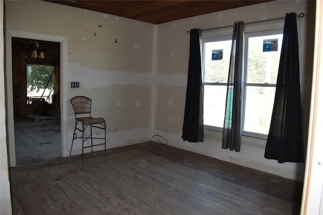 empty room with wood ceiling and dark hardwood / wood-style flooring