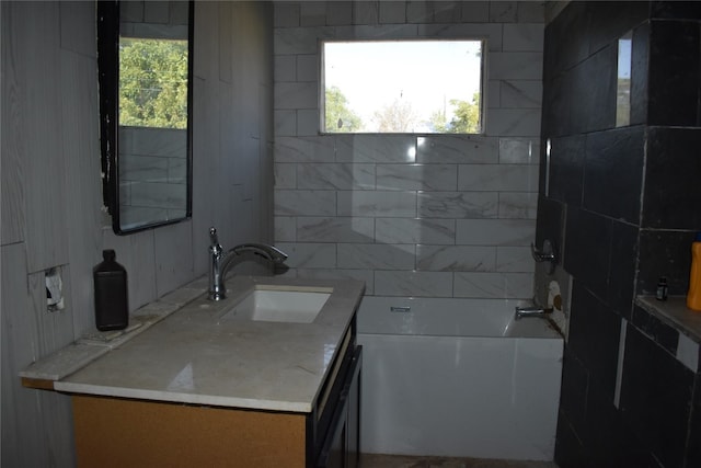 bathroom with a tub to relax in, a wealth of natural light, and vanity