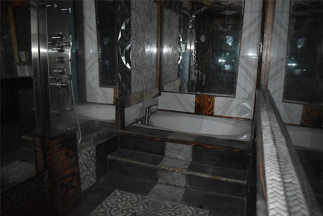 bathroom with a tub to relax in and tile patterned floors