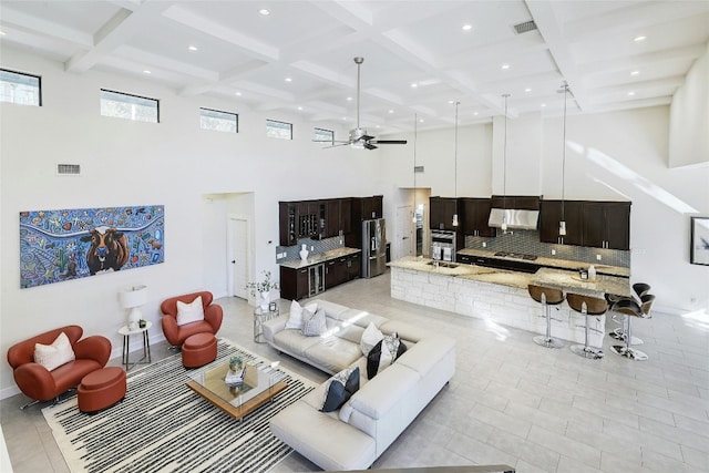 living room with beam ceiling, ceiling fan, and coffered ceiling