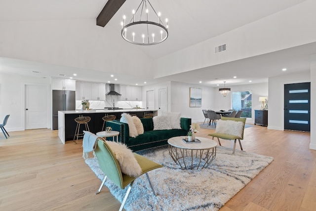 living room with beam ceiling, high vaulted ceiling, light hardwood / wood-style floors, and an inviting chandelier