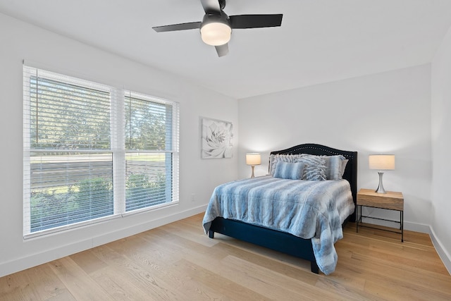 bedroom with multiple windows, ceiling fan, and light hardwood / wood-style flooring