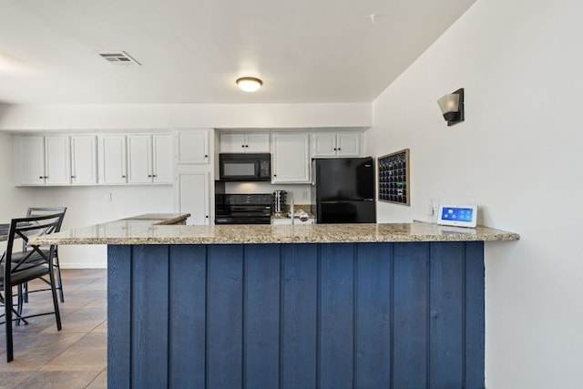 kitchen featuring white cabinetry, visible vents, black appliances, and a peninsula