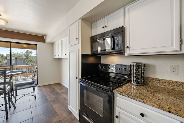 kitchen with light stone counters, white cabinets, baseboards, black appliances, and dark tile patterned floors