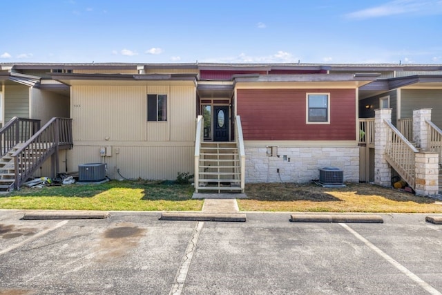 505 Demarett Dr Unit 12, Point Venture, TX 78645 - view of front facade featuring stairway, central AC, and uncovered parking