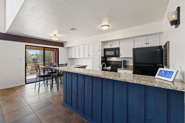 505 Demarett Dr Unit 12, Point Venture, TX 78645 - kitchen with black appliances, white cabinets, and light stone counters