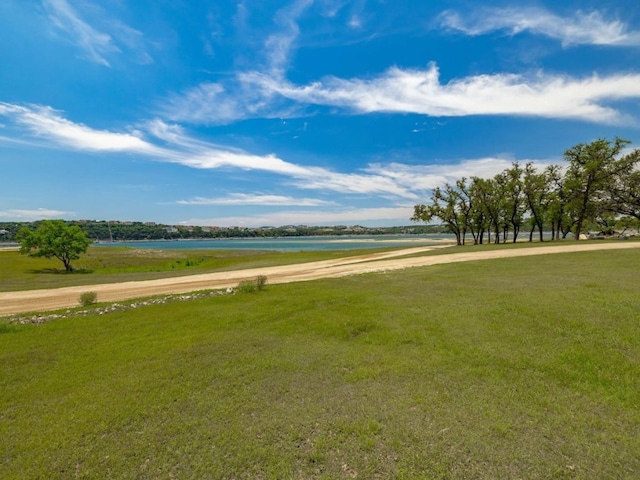 view of home's community with a water view and a yard