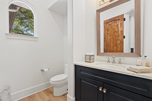 bathroom featuring vanity, toilet, and hardwood / wood-style floors