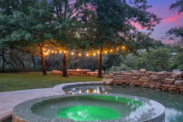 pool at dusk featuring a gazebo, an in ground hot tub, and a yard