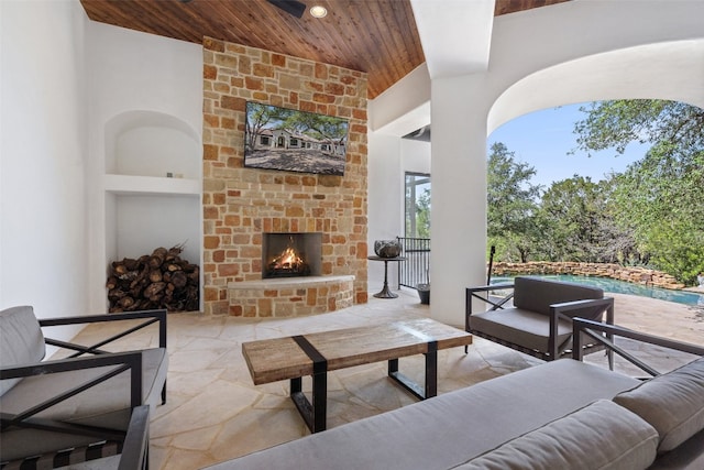 living room featuring an outdoor stone fireplace, built in features, and wooden ceiling