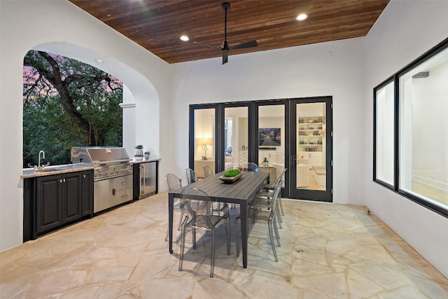 view of patio featuring outdoor dining space, area for grilling, a sink, ceiling fan, and a grill