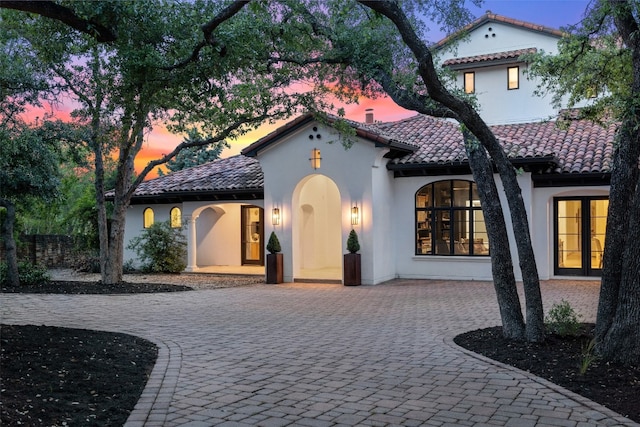 mediterranean / spanish-style house featuring french doors and a patio area