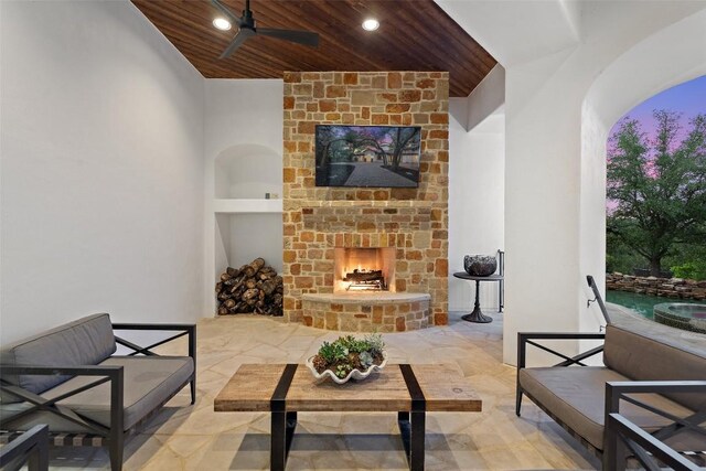 view of patio with ceiling fan and an outdoor stone fireplace