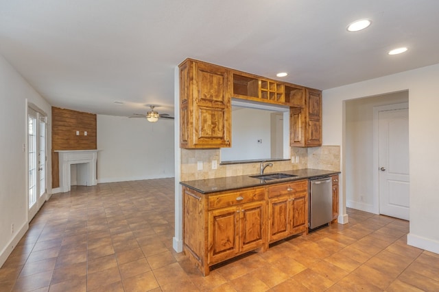 kitchen featuring decorative backsplash, dark stone counters, sink, stainless steel dishwasher, and ceiling fan