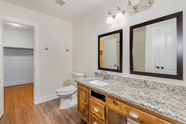 bathroom featuring vanity, hardwood / wood-style floors, and toilet