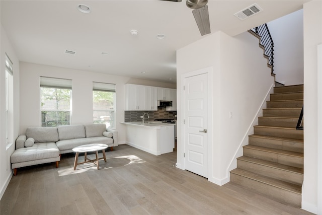 living room with sink and light hardwood / wood-style floors