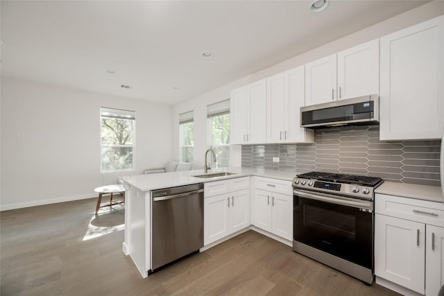 909 Capitol Ct Unit 2, Austin, TX 78756 - kitchen featuring appliances with stainless steel finishes, light wood finished floors, decorative backsplash, light countertops, and recessed lighting