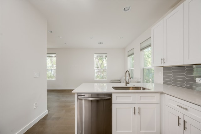 kitchen with sink, dishwasher, kitchen peninsula, dark hardwood / wood-style floors, and white cabinetry