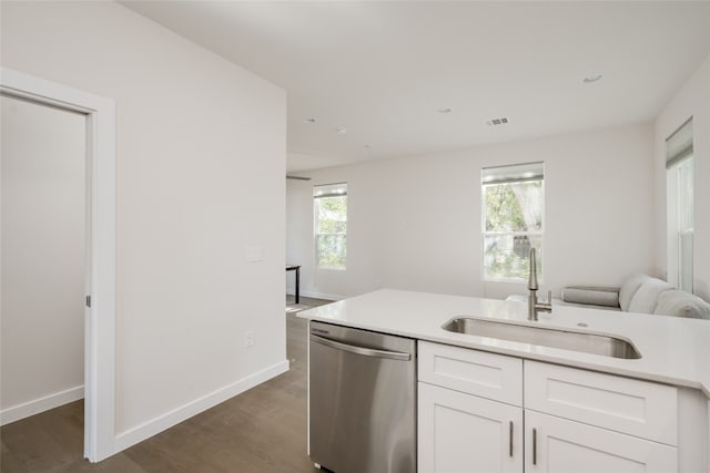 kitchen with sink, a healthy amount of sunlight, stainless steel dishwasher, and white cabinets