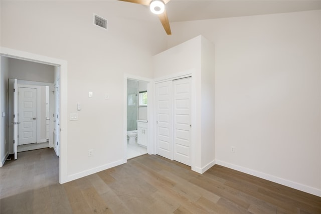 unfurnished bedroom featuring a closet, vaulted ceiling, light wood-type flooring, and ceiling fan