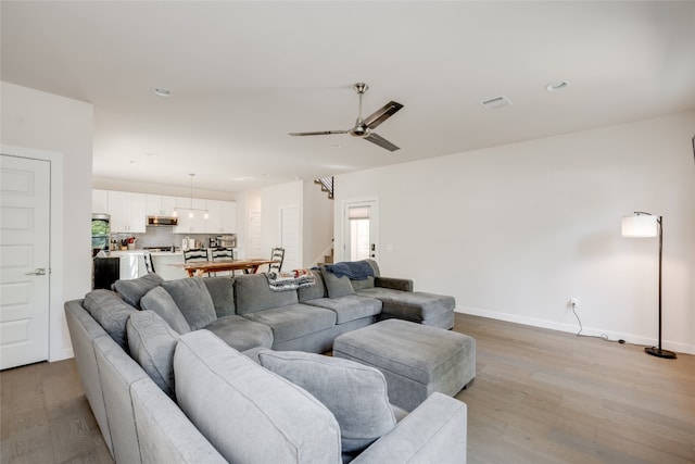 living room featuring ceiling fan and light hardwood / wood-style floors