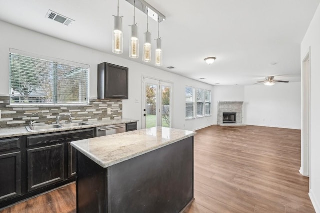 kitchen featuring pendant lighting, a center island, sink, and a wealth of natural light