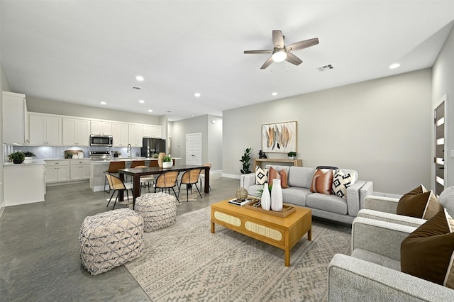 living room with sink, concrete floors, and ceiling fan