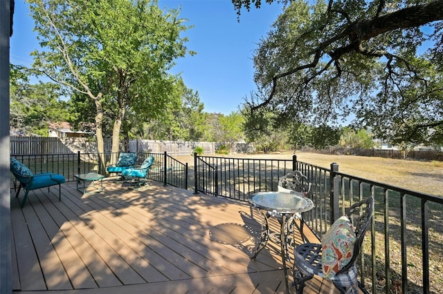 wooden terrace featuring a lawn