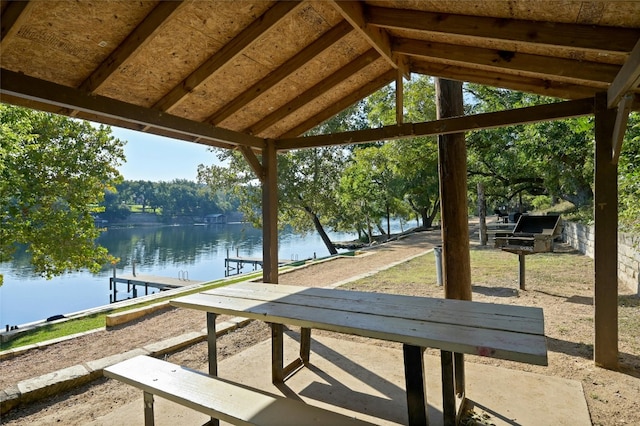 view of patio with a water view and a boat dock