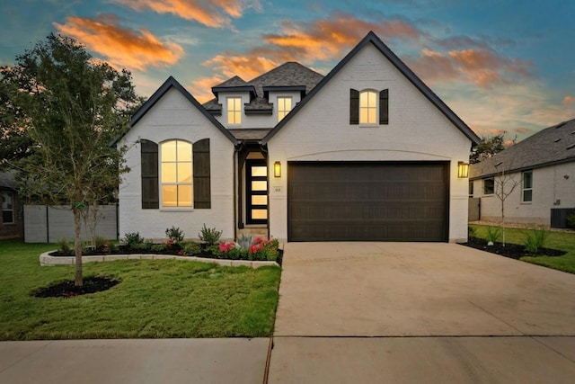 french country home featuring a yard and a garage