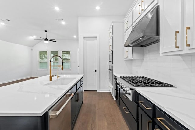 kitchen featuring stainless steel appliances, dark wood-type flooring, sink, white cabinetry, and an island with sink