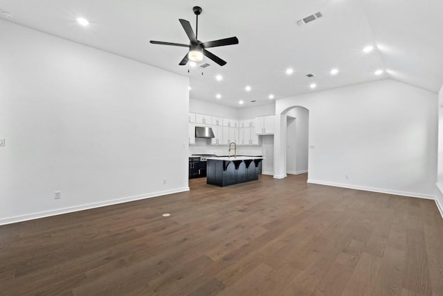 unfurnished living room featuring dark hardwood / wood-style flooring, ceiling fan, lofted ceiling, and sink