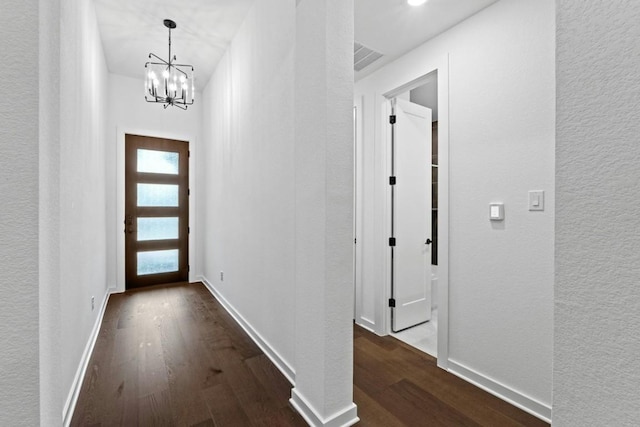 interior space with dark wood-type flooring and a notable chandelier