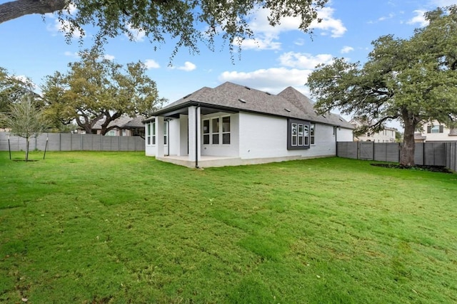 rear view of property featuring a patio and a lawn