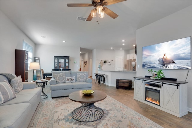 living room featuring light wood-type flooring and ceiling fan